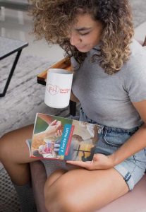 Woman reading A Fertile Heart book with a mug of coffee.